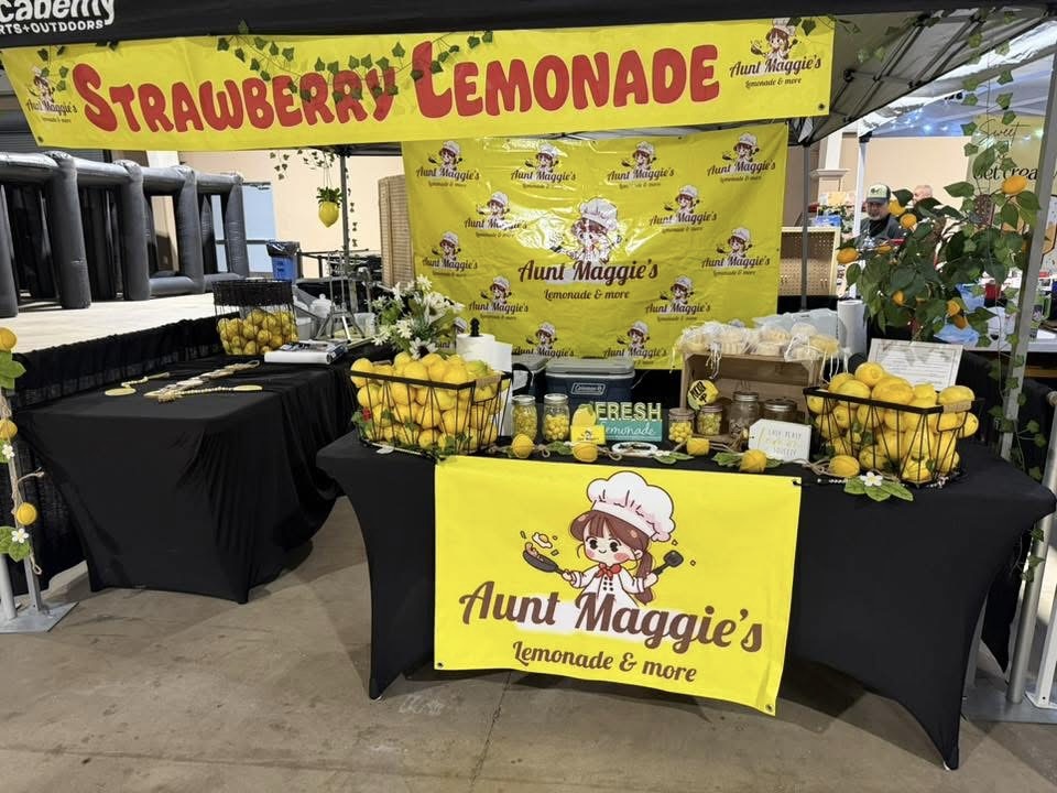Aunt Maggie's booth with yellow banner and baskets of fresh lemons