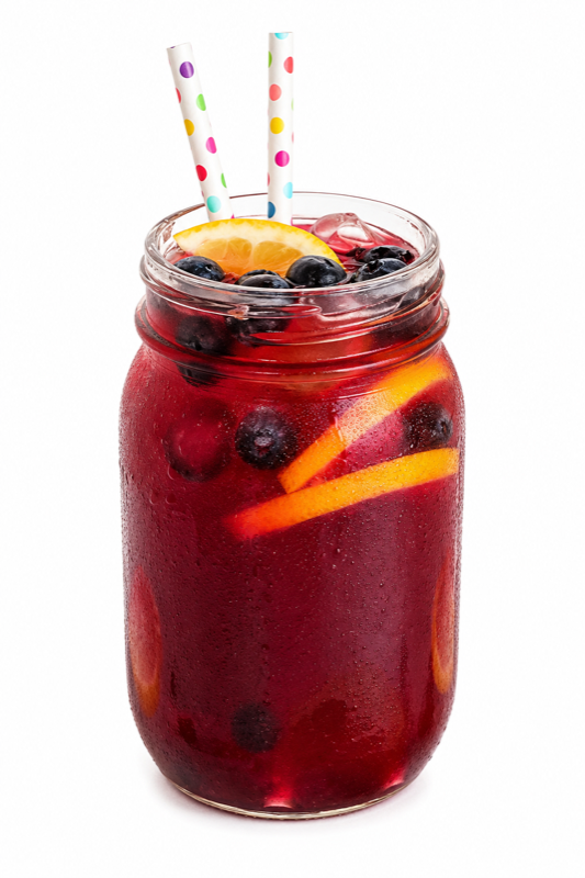 Red berry soda in a mason jar with fruit and straws